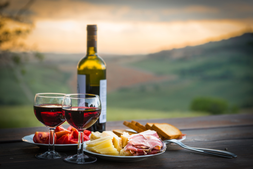 French wine and cheese on the table, with the sunset in the background within the 8 great reasons to visit France