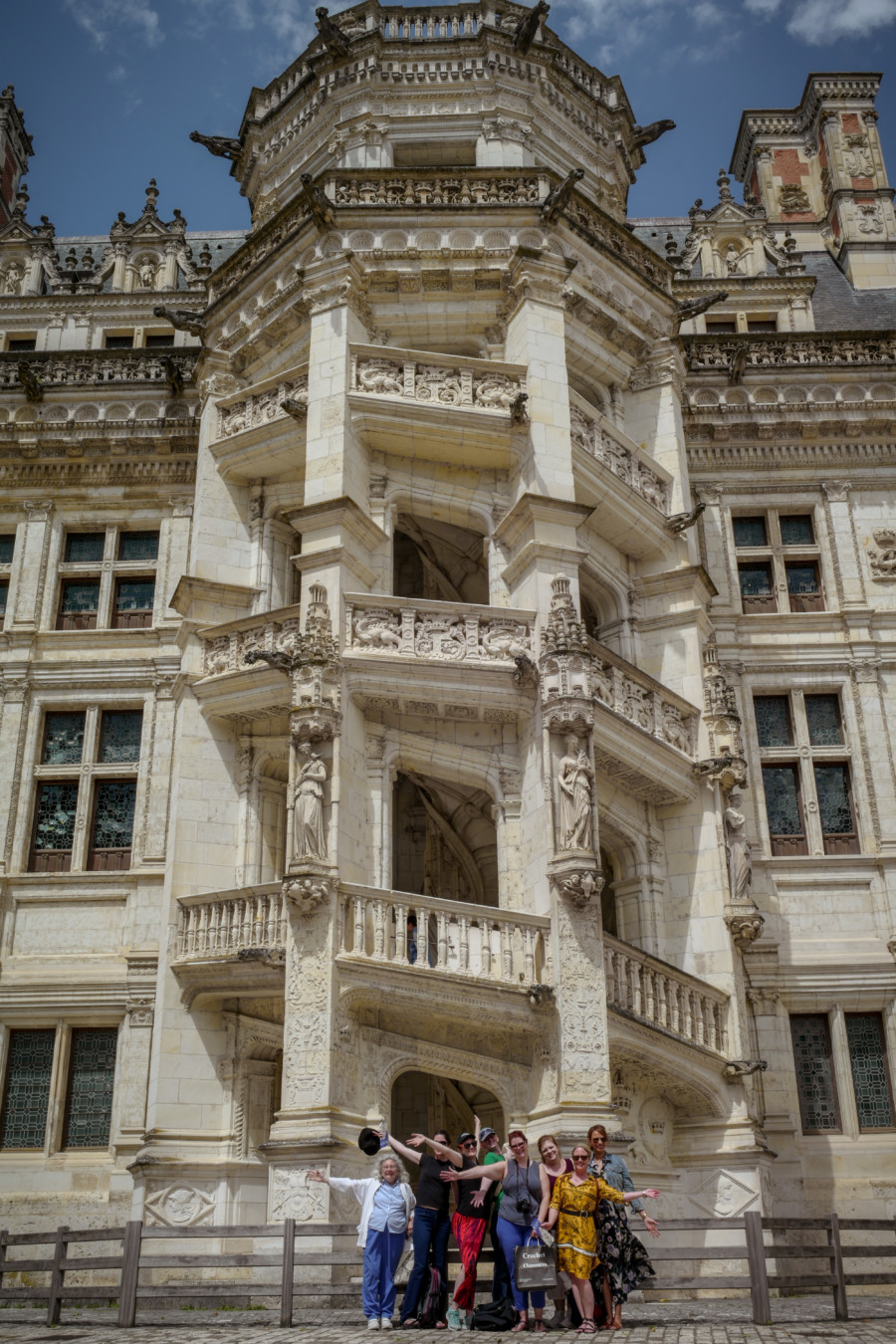 Eight women, posing and smiling in front of the old castle, loire valley tour itinerary