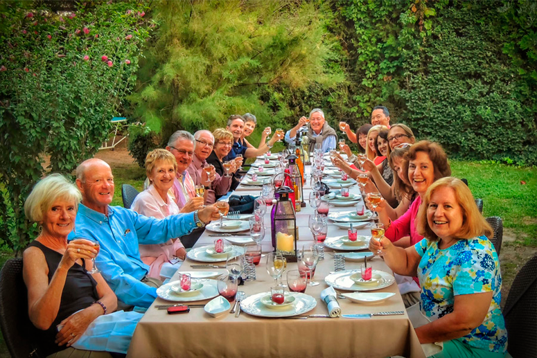 17 setting around the table, posing with the glasses in enchanting outdoor scenery within Provence Tour Itinerary