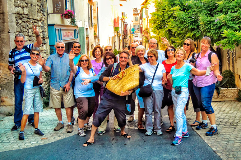 17 people smiling and posing in old town withing the Provence Tour Itinerary