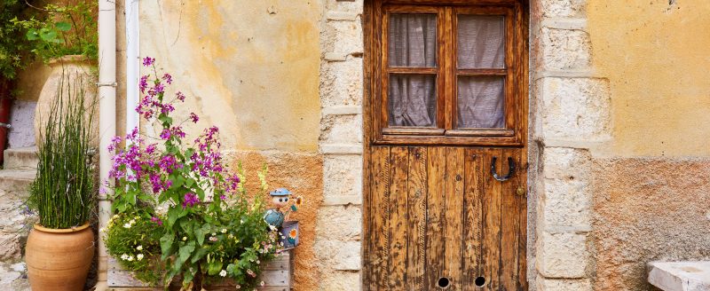 Old rustic door and walls with lavender pot in front