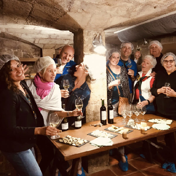 People wine and cheese tasting in rustic basement of an old castle - Bordeaux Tour Itinerary