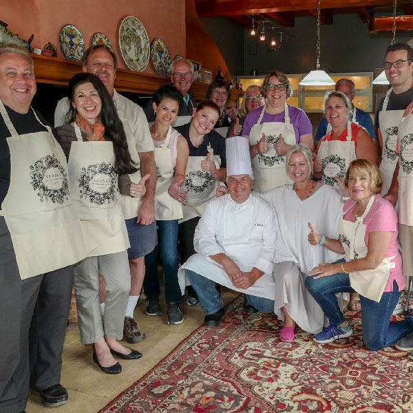 Group of happy people with aprons, attending cooking class within the Bordeaux Tour Itinerary