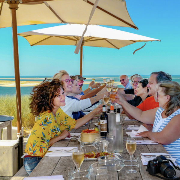 Happy people drinking wine, enjoying sun, on a beach restaurant, Bordeaux Tour Itinerary