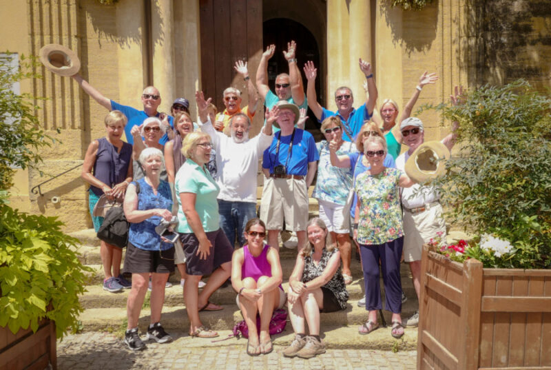 A lot of happy people (tourists) waving to camera