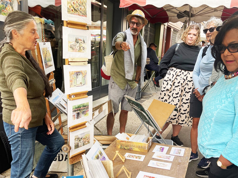 chatting with local artisan on market day in Provence